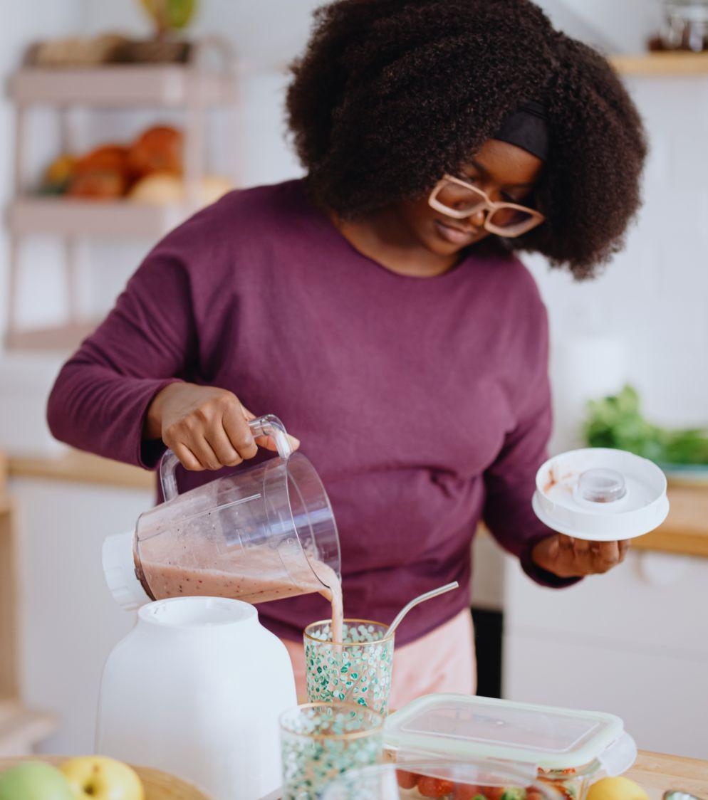 Woman pouring a smoothie into a glass