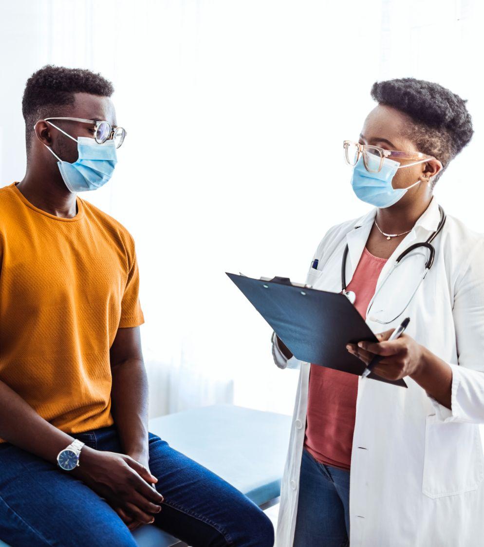 Male patient talking with a female doctor in a doctor’s office