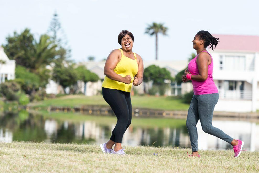 Two women exercising by a lake